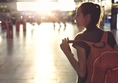 küçük sırt çantası ile terminal havaalanı salonundaki kadın