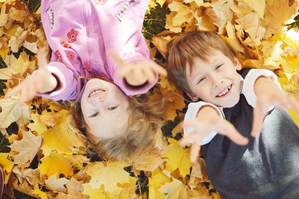 öğrenci ve gülüyor ve sonbahar niteliğine oynayan küçük kız açık havada yürümek