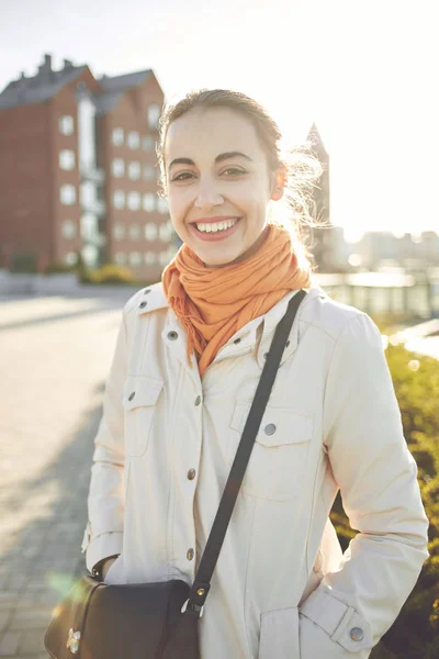 Een mooie jonge vrouw in een beige mantel op wandeling in de herfst — Stockfoto