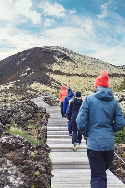 Туристы ходят по тропе среди лавового поля в Исландии — стоковое фото