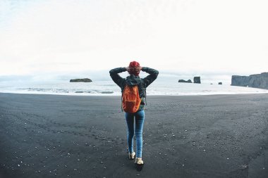 Kirkjufjara siyah kum plaj, Güney İzlanda üzerinde yürüyen kadın.