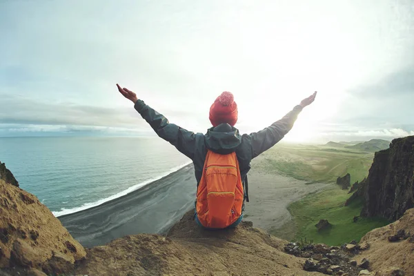 Wanderin mit Rucksack steht auf einem Berg und genießt den Sonnenuntergang in Island — Stockfoto