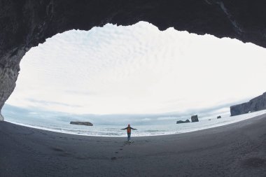 Kirkjufjara siyah kum plaj, Güney İzlanda üzerinde yürüyen kadın.