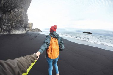 Kirkjufjara siyah kum plaj, Güney İzlanda üzerinde yürüyen kadın.