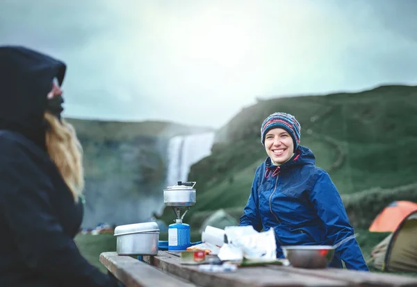 Kvinne på reise tilbereder mat i en kasserolle på en gassbrenner – stockfoto