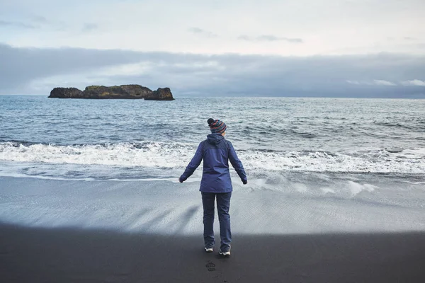 Woman walking on Kirkjufjara black sand beach, southern Iceland. — Stock Photo, Image