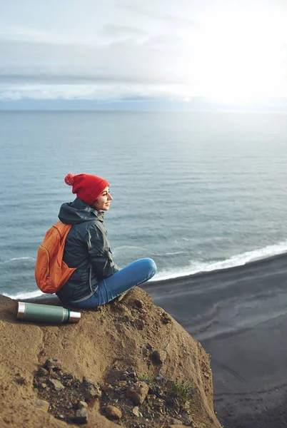 Woman hiker with backpack standing on top of a mountain and enjoying sunset in Iceland — Stock Photo, Image