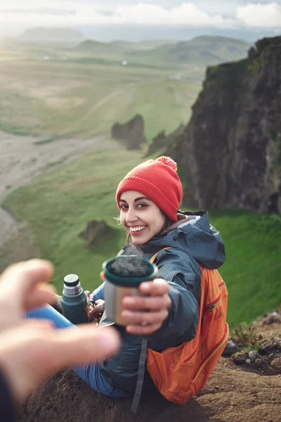Kvinne på fottur med ryggsekk som sitter på et fjell og nyter solnedgang på Island – stockfoto