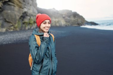 Kirkjufjara siyah kum plaj, Güney İzlanda üzerinde yürüyen kadın.