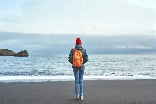 Woman walking on Kirkjufjara black sand beach, southern Iceland. — Stock Photo, Image