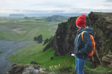 bir dağın tepesinde siting ve günbatımı İzlanda'zevk sırt çantası ile kadın uzun yürüyüşe çıkan kimse