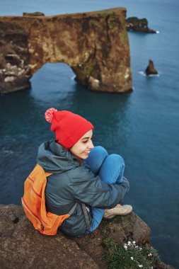 bir dağın tepesinde duran ve günbatımı İzlanda'zevk sırt çantası ile kadın uzun yürüyüşe çıkan kimse