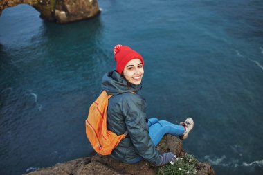 bir dağın tepesinde duran ve günbatımı İzlanda'zevk sırt çantası ile kadın uzun yürüyüşe çıkan kimse