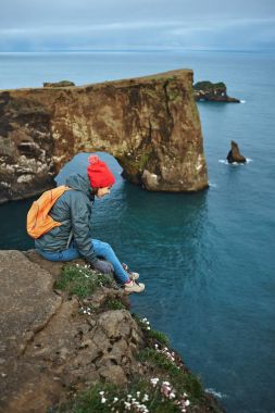 bir dağın tepesinde duran ve günbatımı İzlanda'zevk sırt çantası ile kadın uzun yürüyüşe çıkan kimse