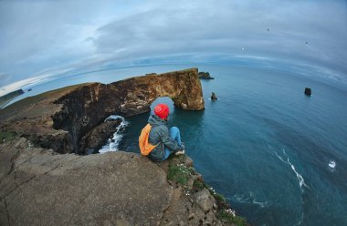 bir dağın tepesinde duran ve günbatımı İzlanda'zevk sırt çantası ile kadın uzun yürüyüşe çıkan kimse