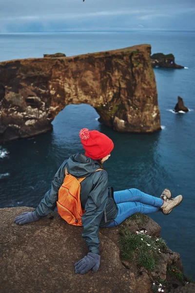 Woman hiker with backpack standing on top of a mountain and enjoying sunset in Iceland — Stock Photo, Image