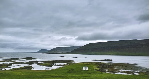 Красивый исландский пейзаж с зелеными полями, горами, небом и облаками . — стоковое фото