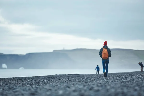 Woman walking on Reynisfjara black sand beach, southern Iceland. — Stock Photo, Image