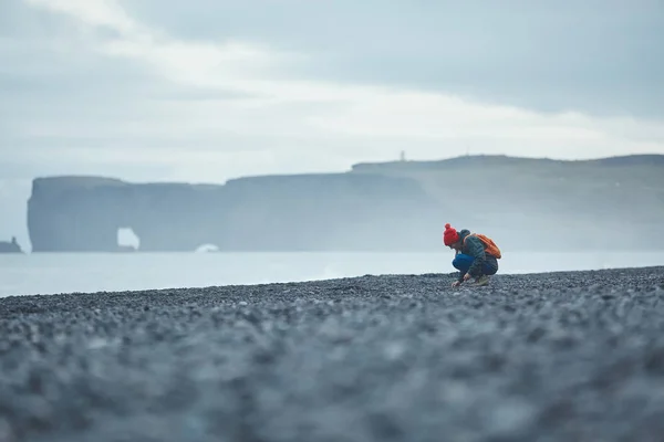 Женщина, идущая по черному песчаному пляжу Рейнисфьяры, южная Исландия . — стоковое фото