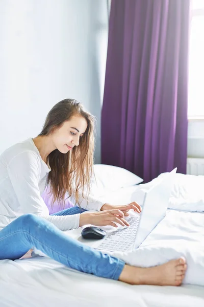 Nuori hymyilevä nainen kannettavan tietokoneen kanssa — kuvapankkivalokuva