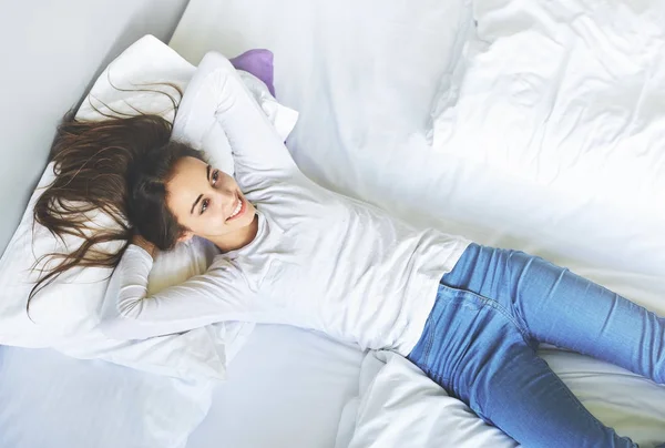 Genç kadın yatakta yatarken — Stok fotoğraf