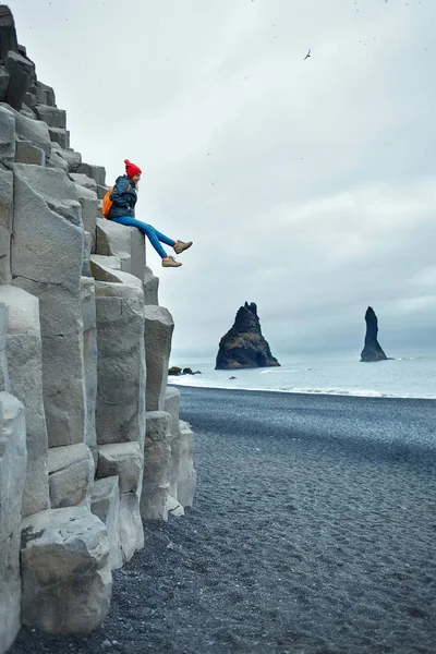 Woman posing sitting on basalt columns at Black Beach in Iceland — Stock Photo, Image