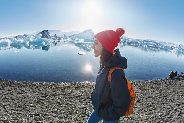 Kvinna med ryggsäck i Ice Lagoon i Island — Stockfoto
