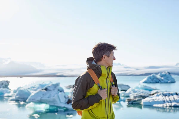 Mannen med ryggsäck i Ice Lagoon i Island — Stockfoto