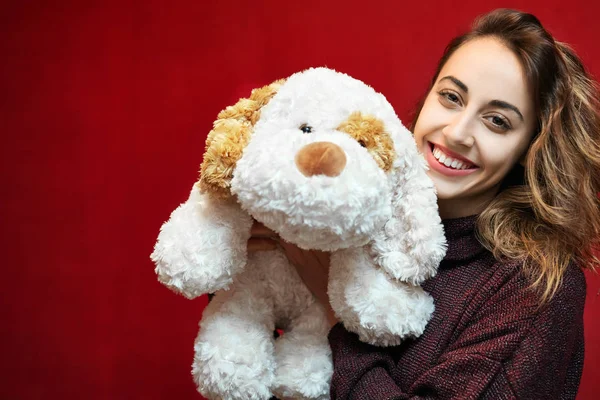 Glad vacker kvinna med en leksak hund — Stockfoto