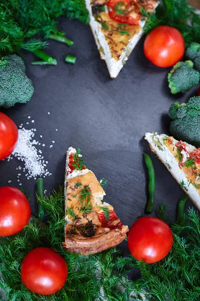 pieces of vegetable pie with cottage cheese, tomatoes, dill and asparagus beans on a dark ceramic background.