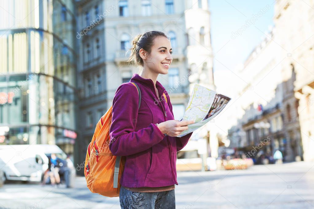 a woman tourist in the center of Prague with a map in the hands of