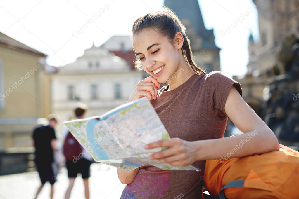 a woman tourist in the center of Prague with a map in the hands of