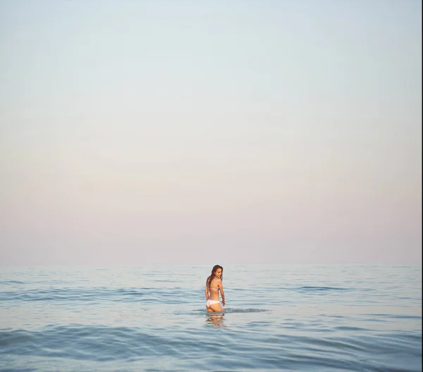 Hermosa mujer sexual contra el mar y la puesta de sol — Foto de Stock