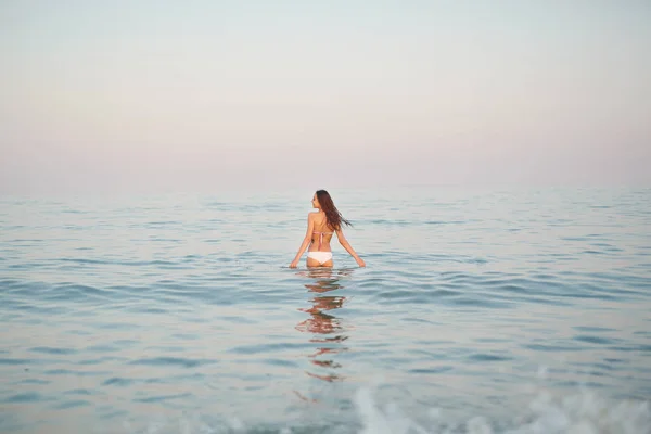 Hermosa mujer sexual contra el mar y la puesta de sol — Foto de Stock