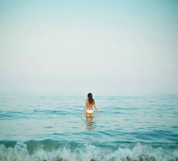 Kaunis seksuaalinen nainen merta ja auringonlaskua vastaan — kuvapankkivalokuva