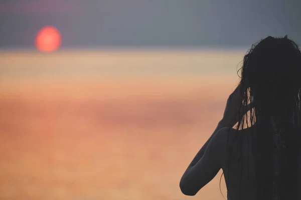 Silhuett av en vakker pike mot havet og solnedgang – stockfoto