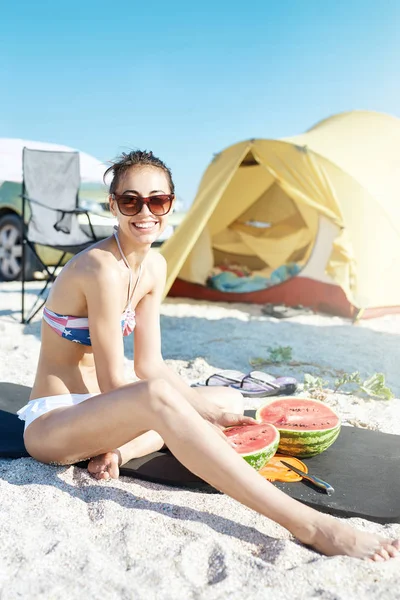 Молода красива жінка збирається з'їсти кавун на пляжі — стокове фото