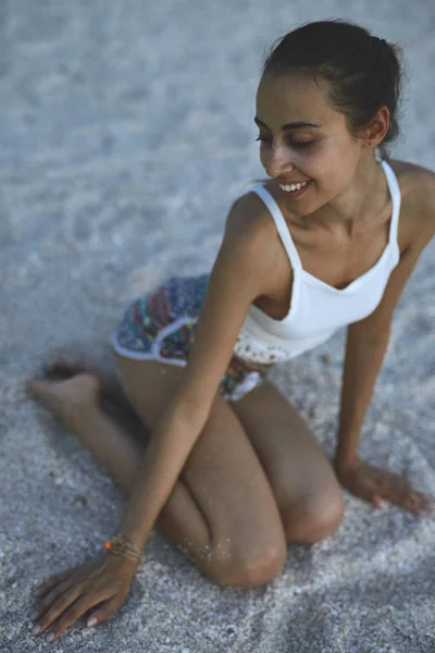 Vakker kvinne sitter på stranden – stockfoto