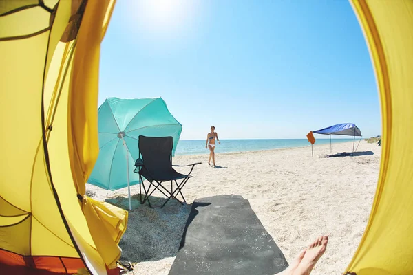 Вид изнутри палаток на песчаный пляж и море в яркий солнечный день — стоковое фото