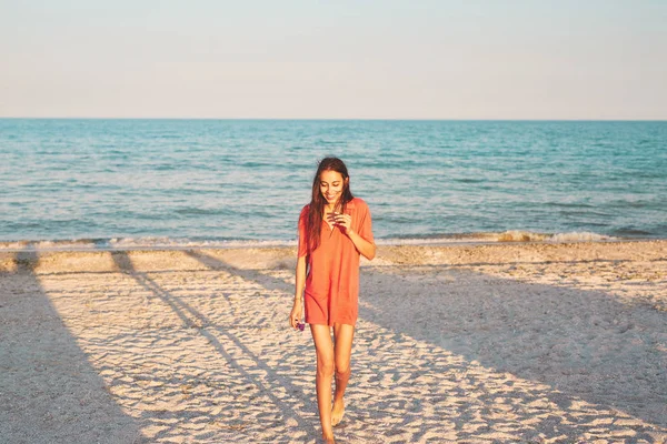 Hermosa mujer contra el mar al atardecer — Foto de Stock