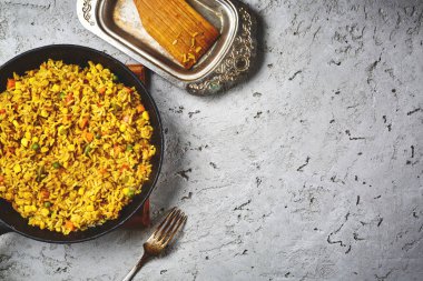 bir siyah dökme demir tavada bir gri beton zemin üzerinde yukarıdan bir risotto sebze ve vejeteryan pancar Beşamel sos ile servis