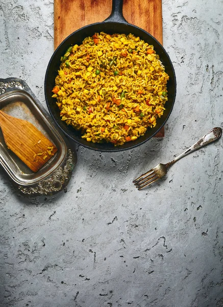 Vista superior de un risotto con verduras y chuletas de remolacha vegana servidas en una sartén de hierro fundido negro sobre un fondo de hormigón gris — Foto de Stock