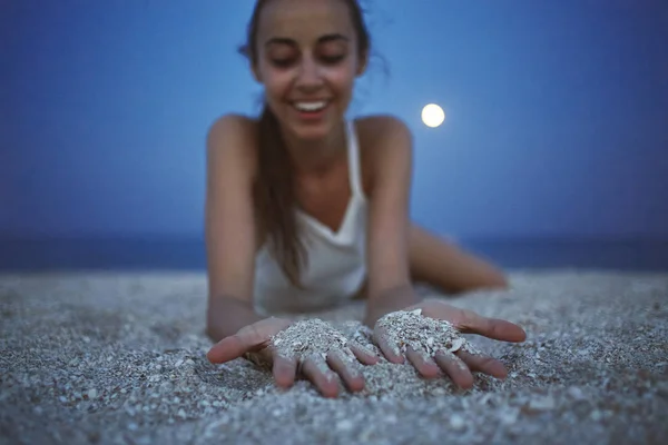 Kaunis nainen istuu hiekalla rannalla — kuvapankkivalokuva