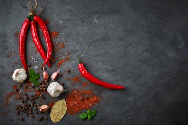 Arka plan ile pul biber, sarımsak ve baharat karanlık taş masada yemek yiyecek.