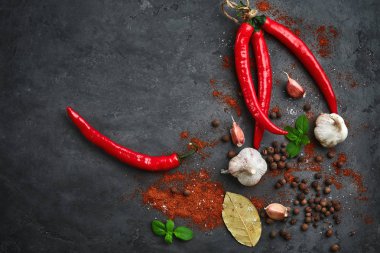 Arka plan ile pul biber, sarımsak ve baharat karanlık taş masada yemek yiyecek.