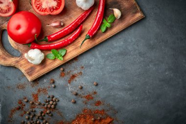 domates, biber, sarımsak ve baharat karanlık taş masada ahşap catboard üzerinde ürün kümesiyle.