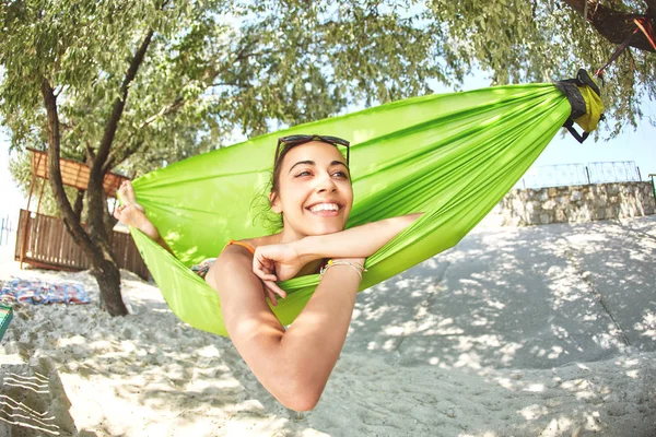 Gelukkig jongedame in een hangmat op het strand — Stockfoto