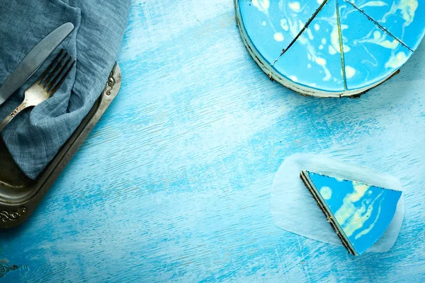 Taart en mousse cake met blauwe glaze stuk gesneden op de houten achtergrond wit-blauw — Stockfoto