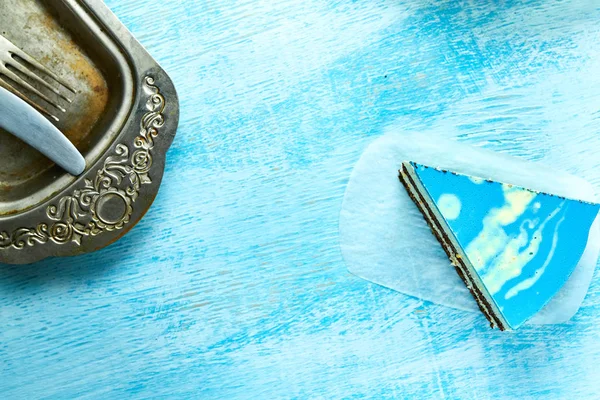 Stuk van mousse taart met blauwe glazuur op de houten achtergrond wit-blauw — Stockfoto