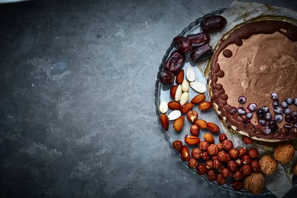 Chocolate vegan cake with different nuts, dates and carob